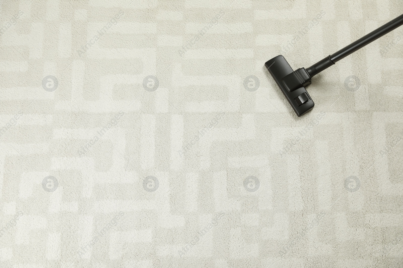 Photo of Removing dirt from white carpet with modern vacuum cleaner, top view. Space for text