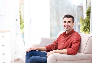 Photo of Young man resting on sofa at home