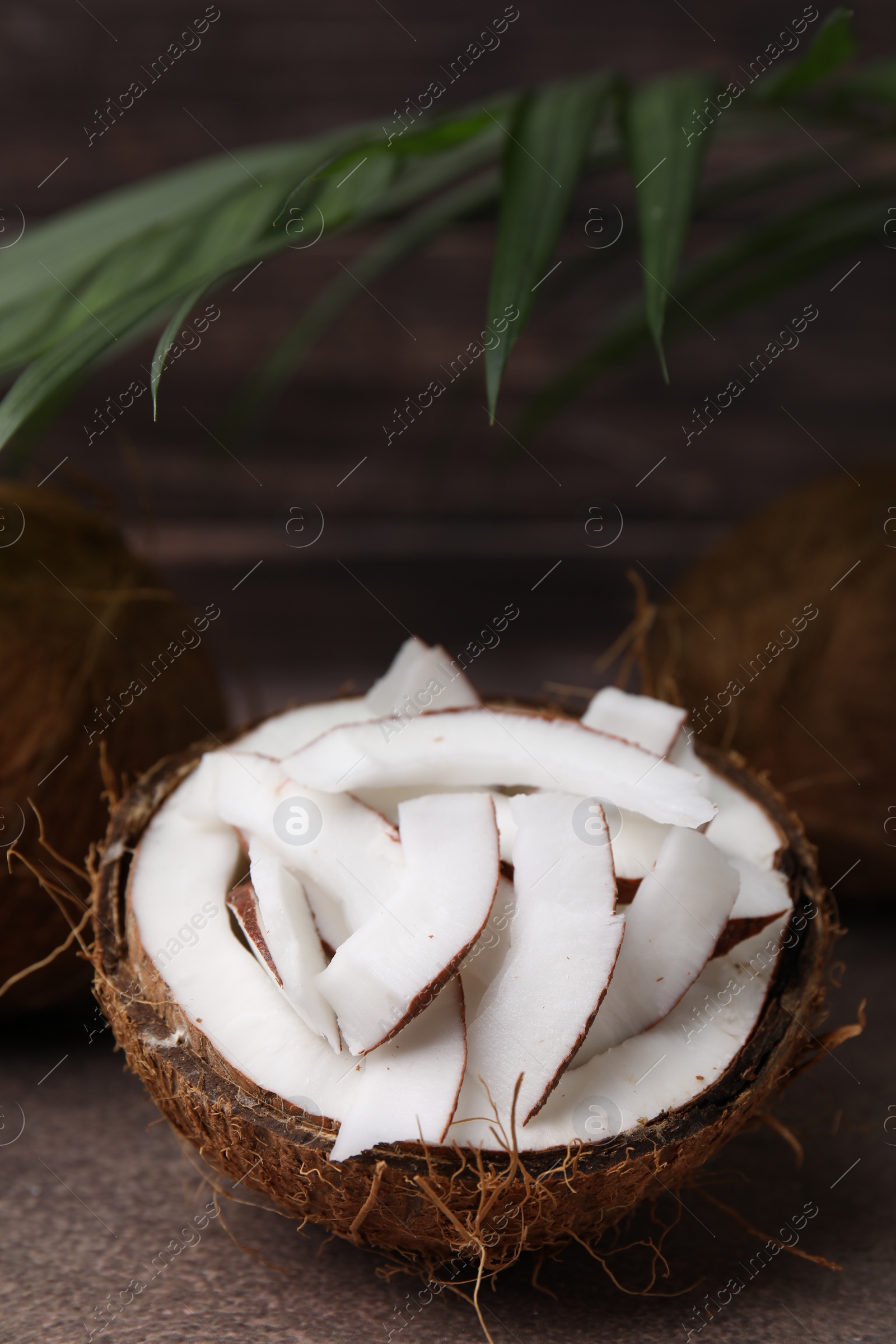 Photo of Coconut pieces in nut shell on brown table