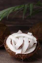 Coconut pieces in nut shell on brown table