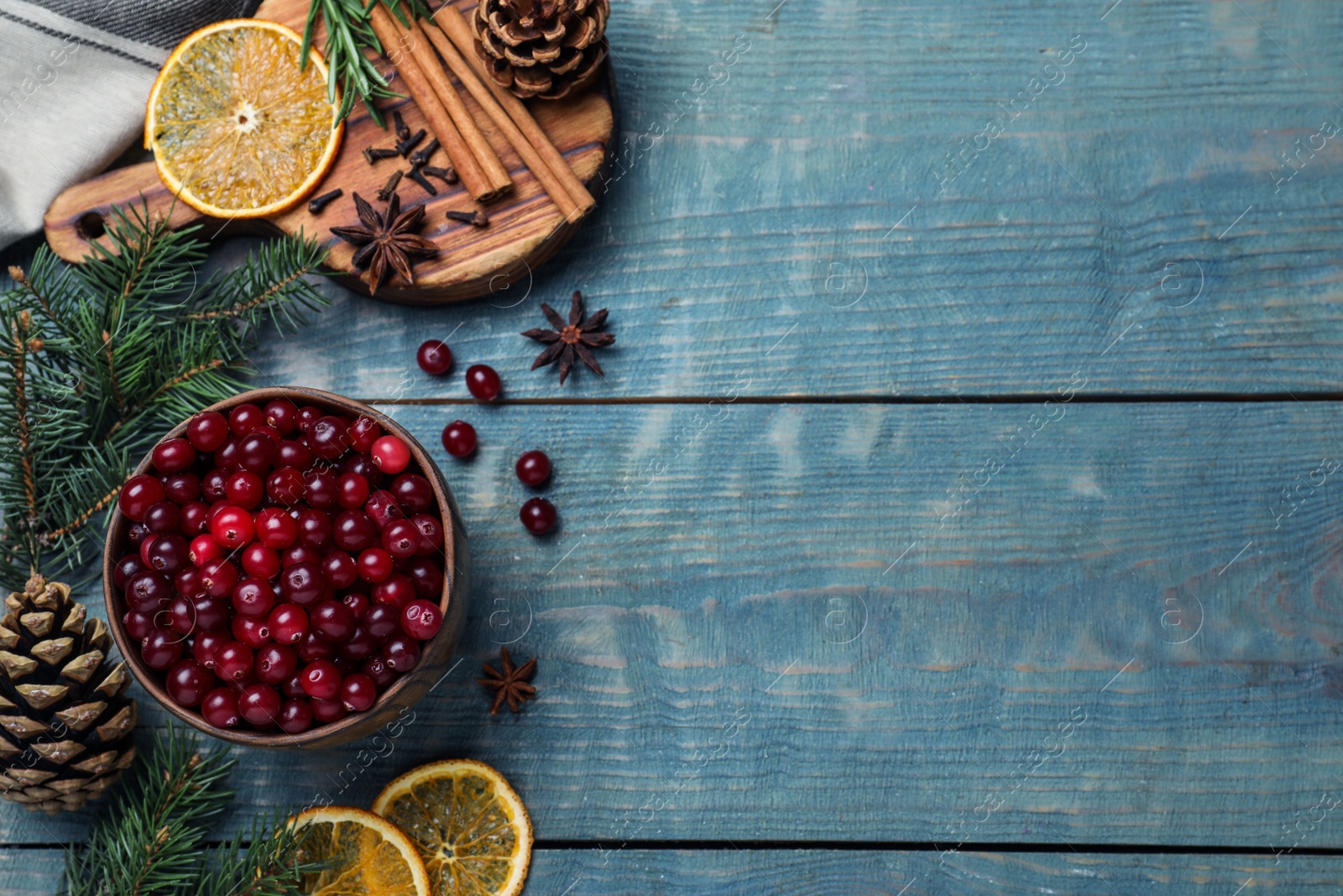 Photo of Flat lay composition with fresh ripe cranberries on blue wooden table. Space for text