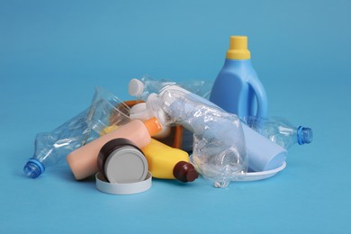 Pile of plastic garbage on light blue background