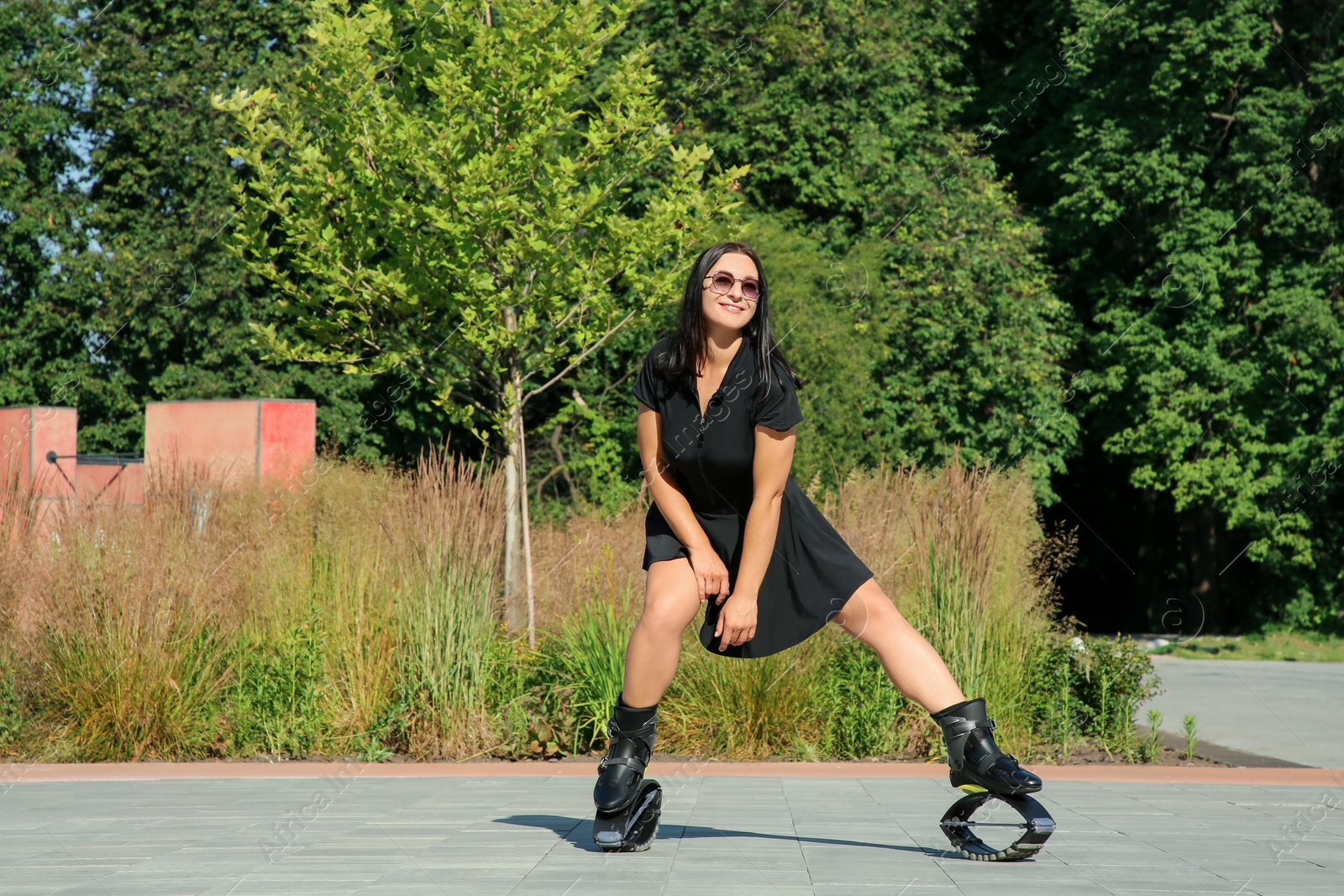 Photo of Woman doing exercises in kangoo jumping boots outdoors