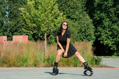 Photo of Woman doing exercises in kangoo jumping boots outdoors