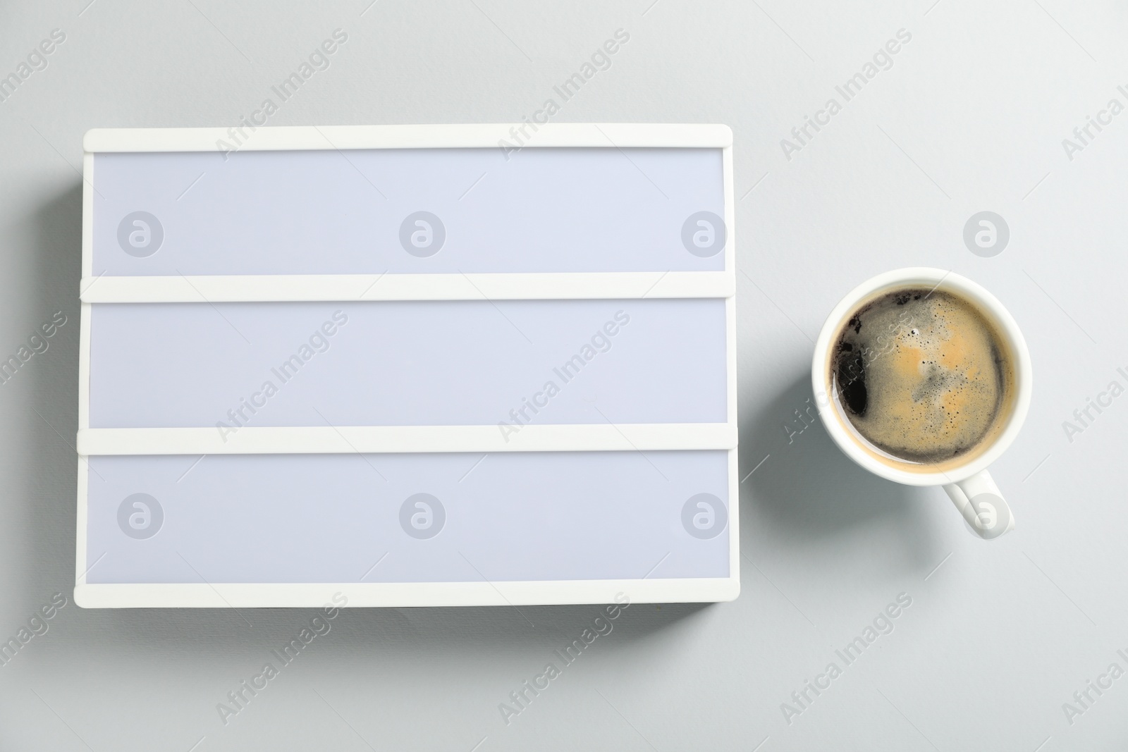 Photo of Blank letter board and coffee on white background, flat lay