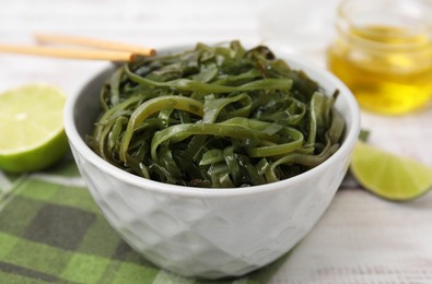 Photo of Tasty seaweed salad in bowl served on table, closeup