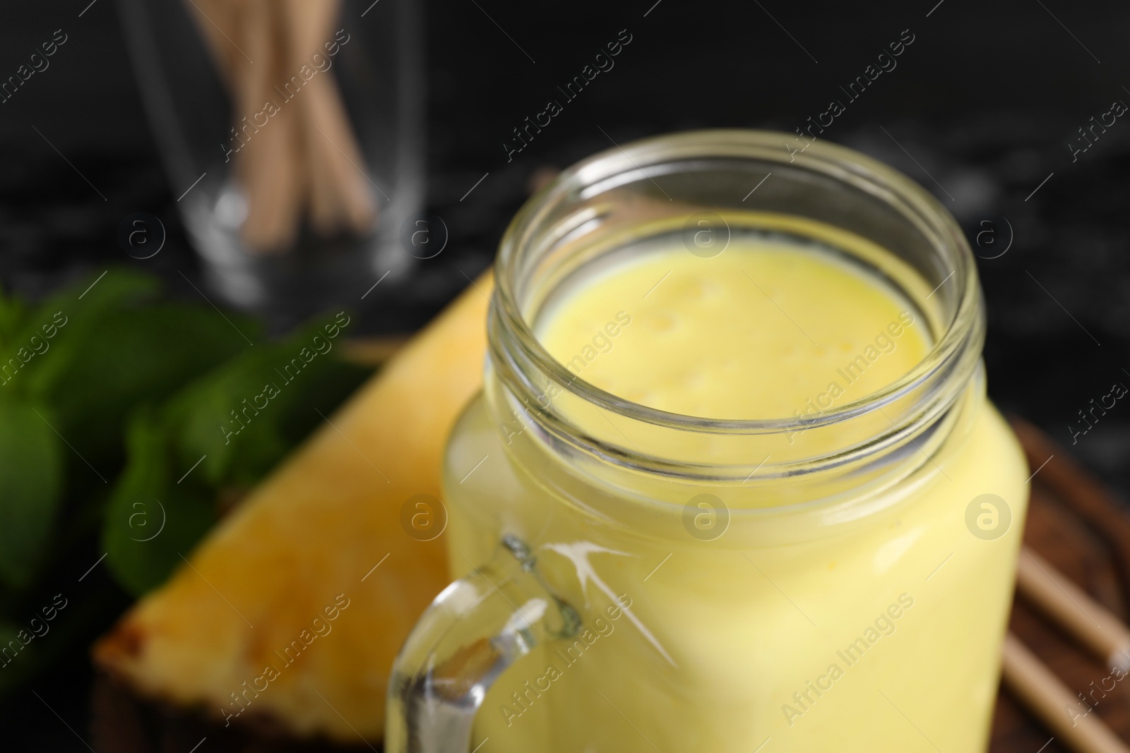 Tasty pineapple smoothie in mason jar, closeup. Space for text Photo of Tasty pineapple smoothie in mason jar, closeup. Space for text
