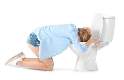 Photo of Young woman vomiting in toilet bowl on white background