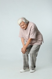 Photo of Full length portrait of senior woman having knee problems on grey background