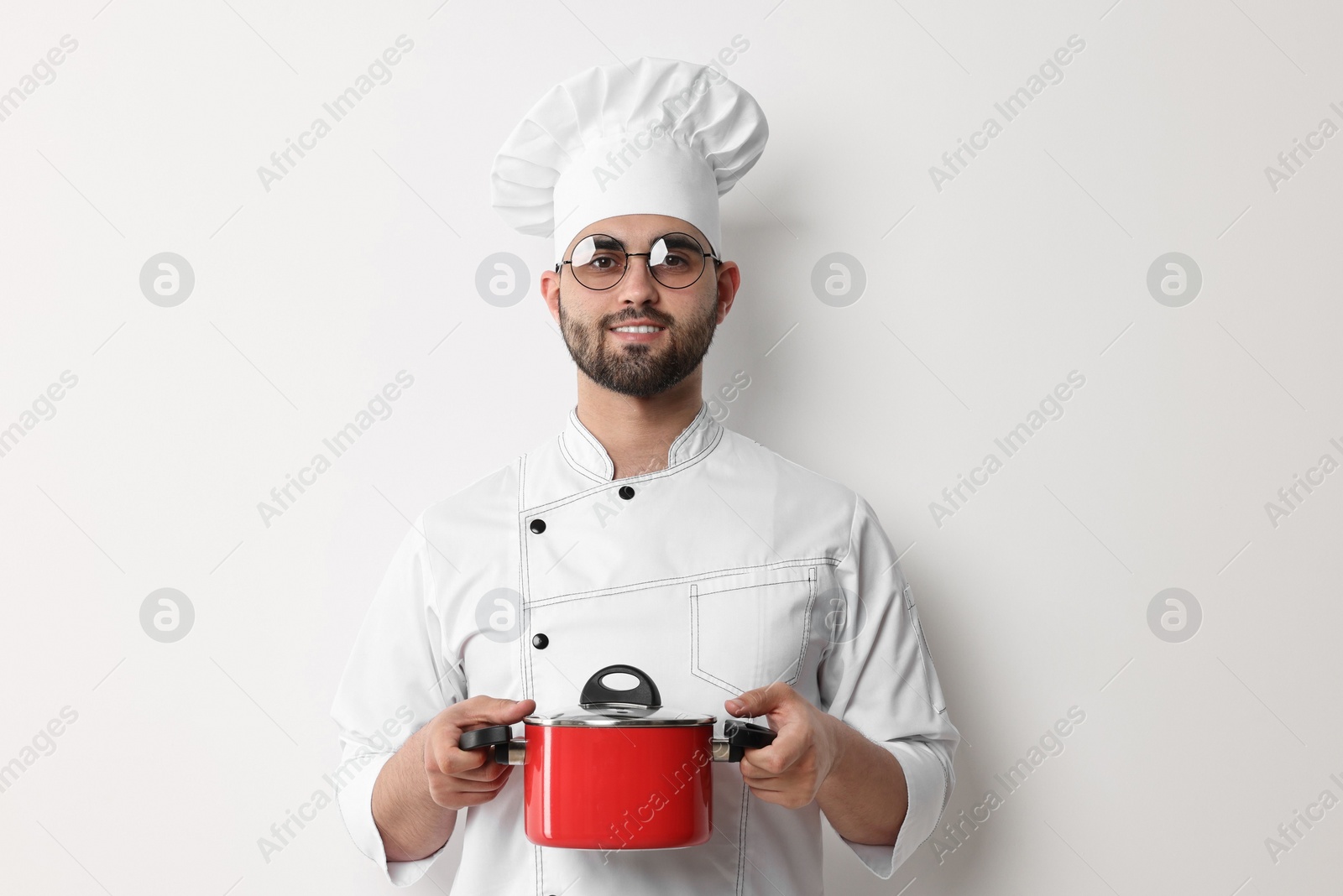 Photo of Professional chef with cooking pot on white background