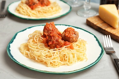 Delicious pasta with meatballs and tomato sauce on table