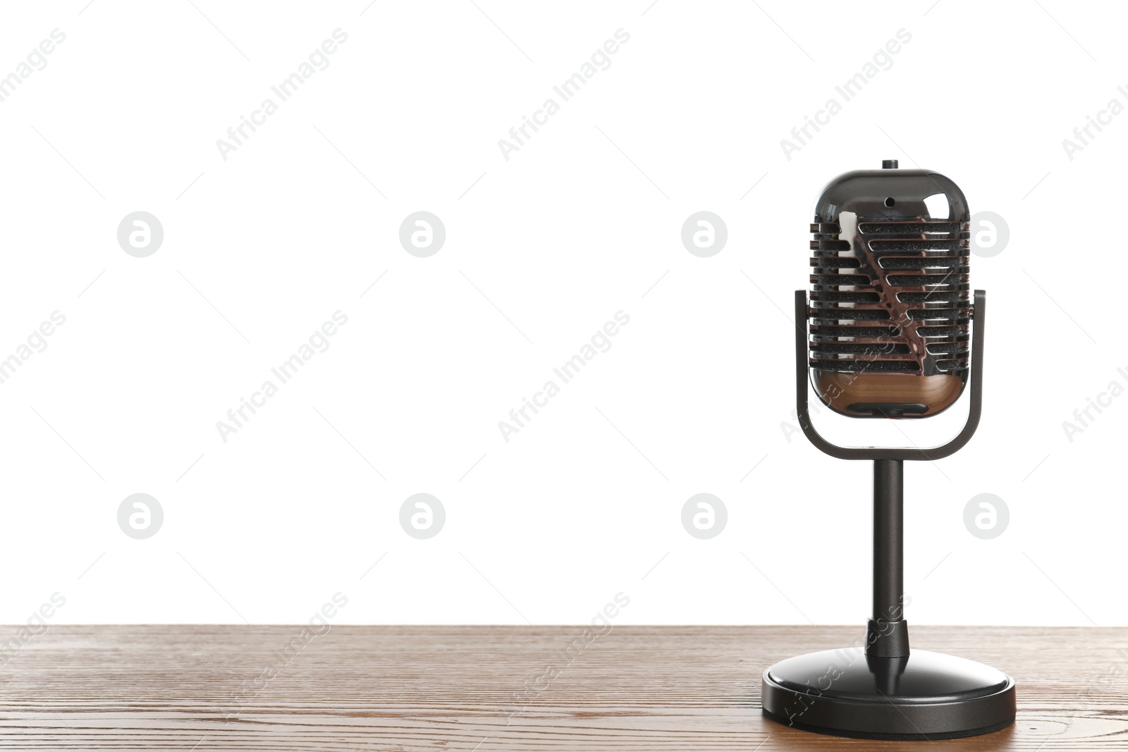 Photo of Retro microphone on table against white background. Space for text