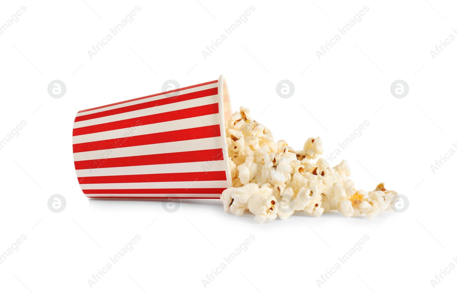 Photo of Overturned paper cup with delicious popcorn isolated on white