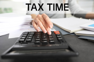 Image of Tax accountant working with calculator and documents at table, closeup
