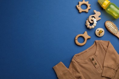Flat lay composition with baby clothes and accessories on blue background, space for text