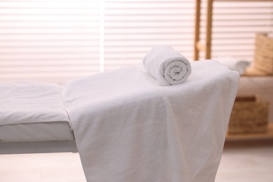 Rolled towel on massage table in spa center