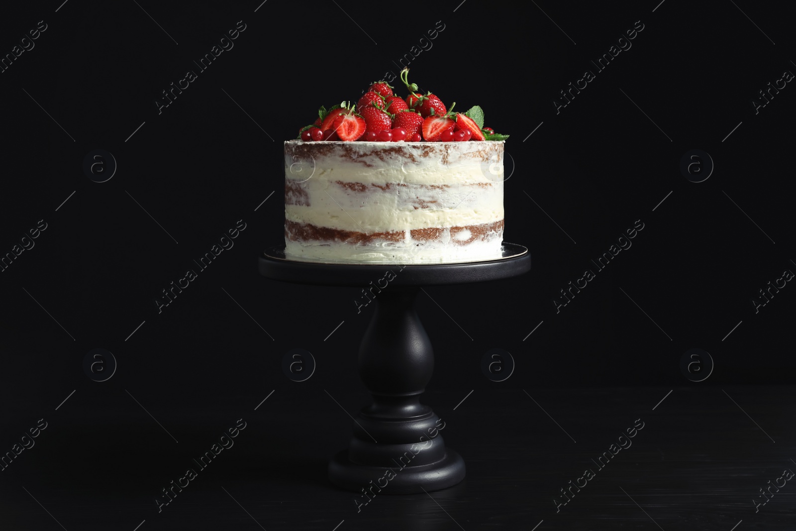 Photo of Delicious homemade cake with fresh berries on black background