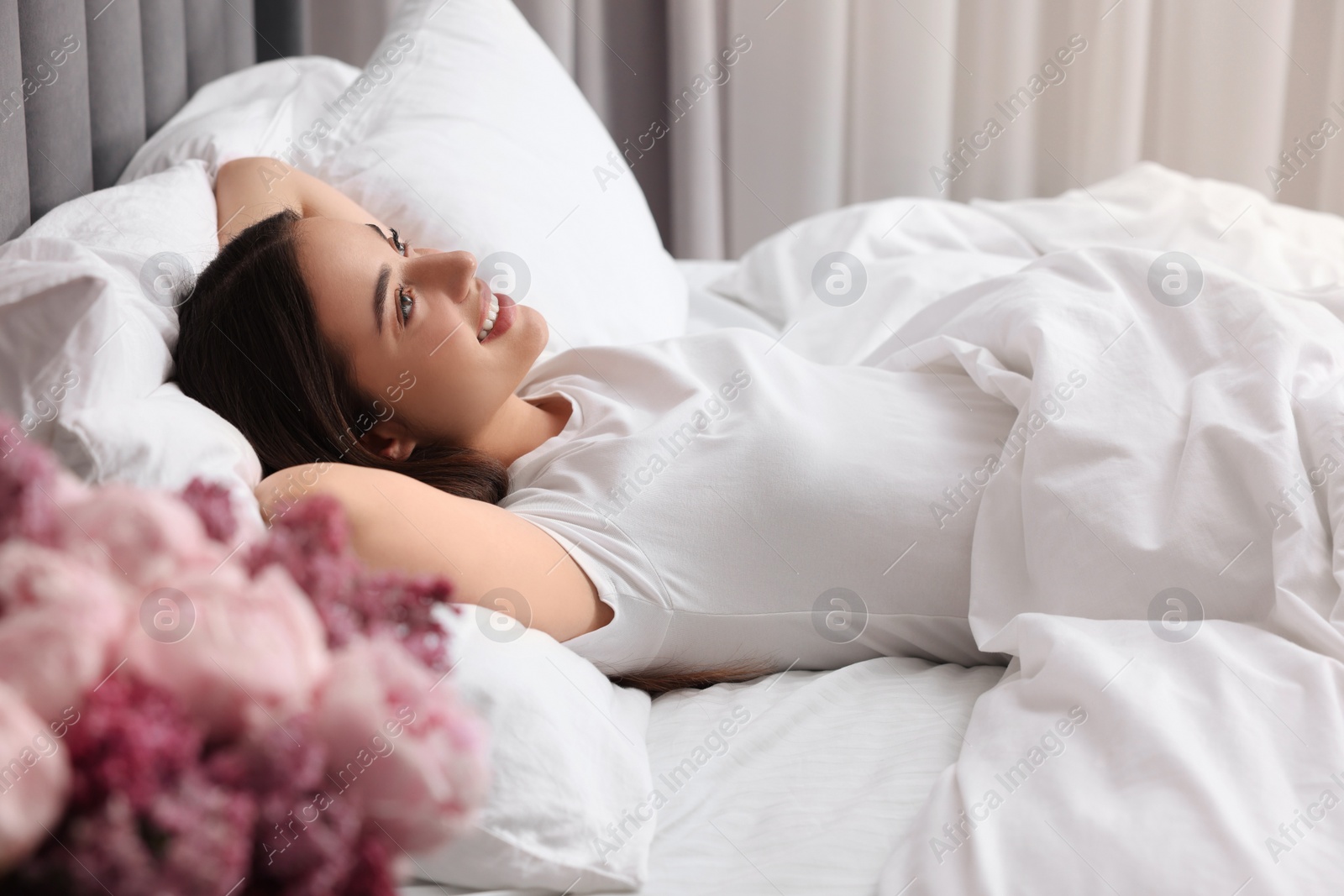 Photo of Happy woman in bed at home. Lazy morning