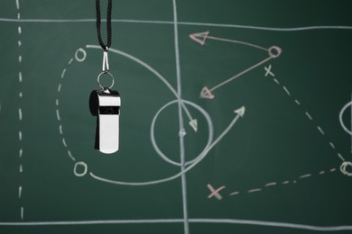 Photo of Referee whistle against green chalkboard with game scheme, space for text