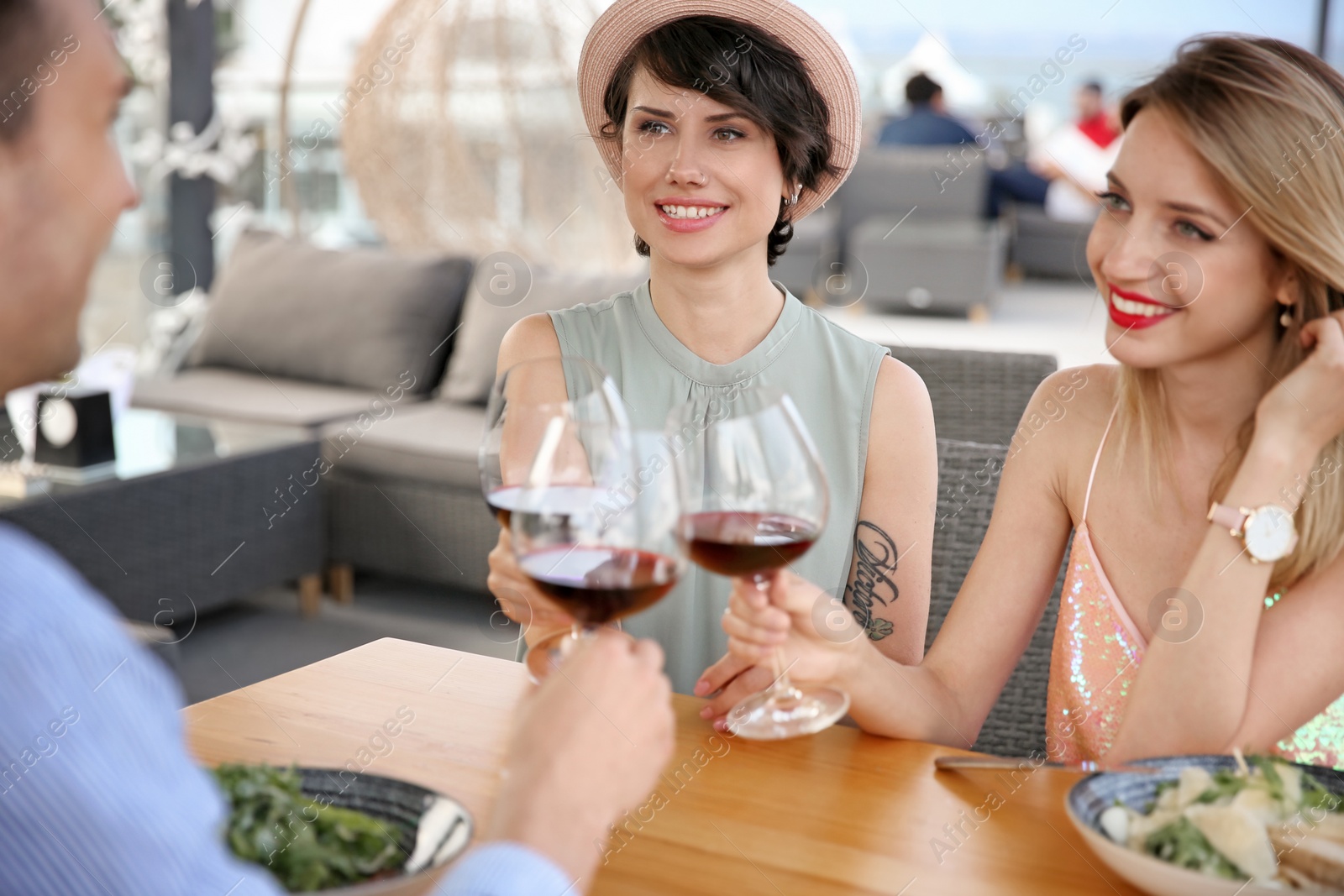 Photo of Group of friends with glasses of wine at table