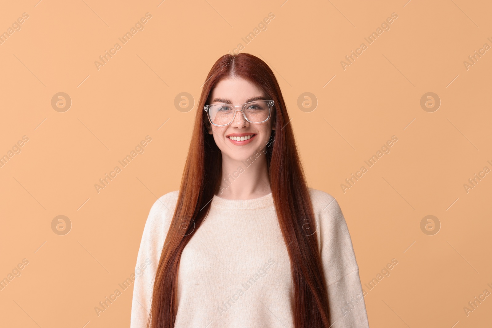 Photo of Portrait of smiling woman in glasses on beige background
