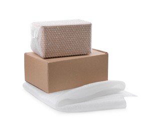 Photo of Cardboard boxes with bubble wrap and packaging foam on white background