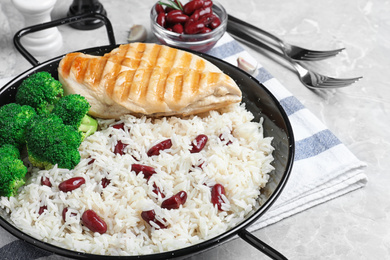 Photo of Tasty rice with beans on light grey marble table, closeup