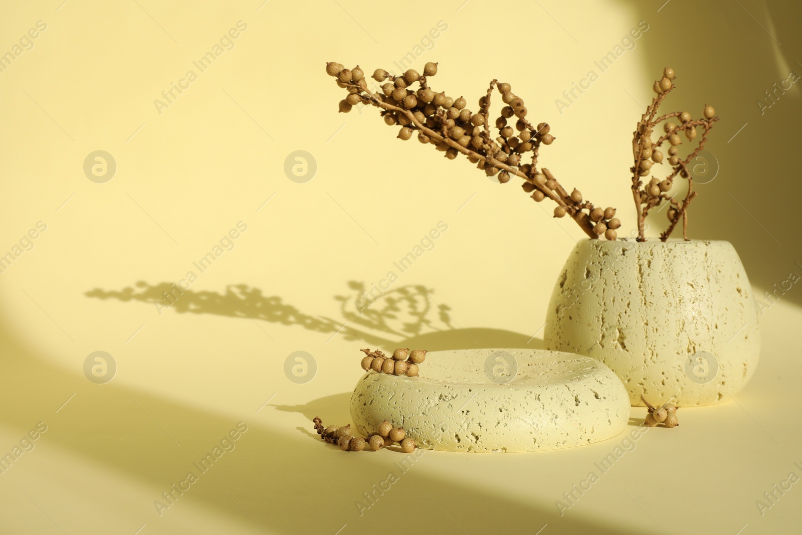 Photo of Presentation of product. Stone podium and vase with beautiful branches on yellow background. Space for text