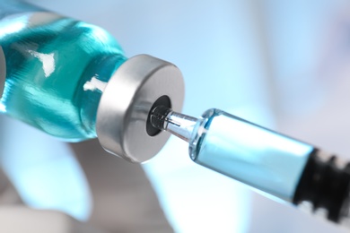 Photo of Filling syringe with vaccine from vial, closeup