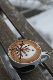 Photo of Cuparomatic coffee on wooden bench outdoors in winter