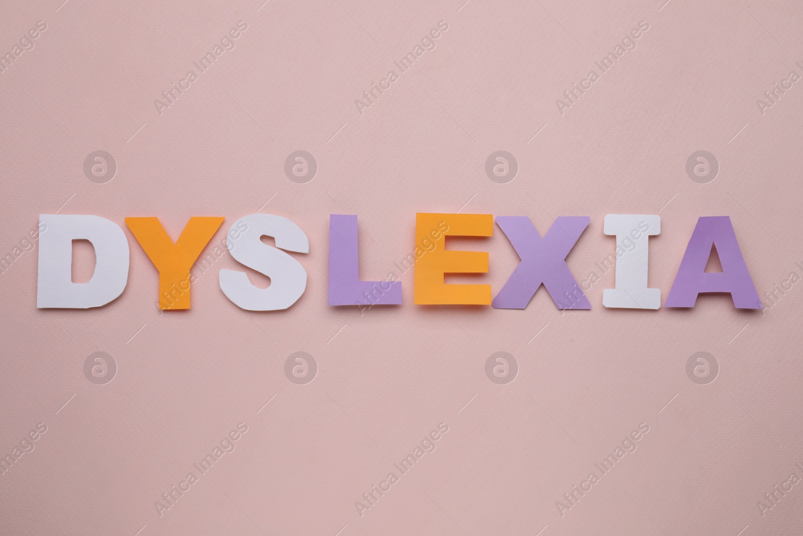 Photo of Word Dyslexia made of paper letters on beige background, flat lay