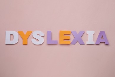 Word Dyslexia made of paper letters on beige background, flat lay