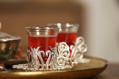 Photo of Glasses with tasty Turkish tea on table indoors, closeup