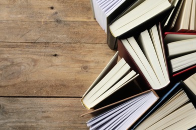 Hardcover books on wooden table, flat lay. Space for text