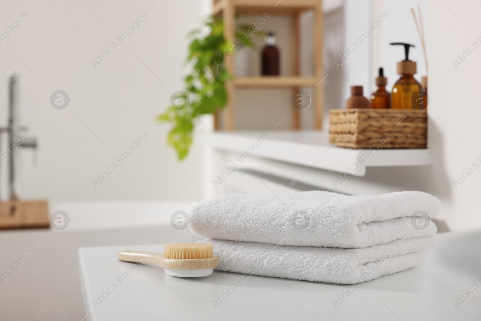 Photo of Stacked soft towels on white table in bathroom. Space for text