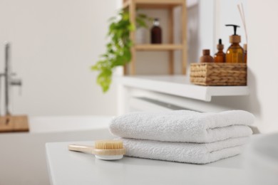 Photo of Stacked soft towels on white table in bathroom. Space for text