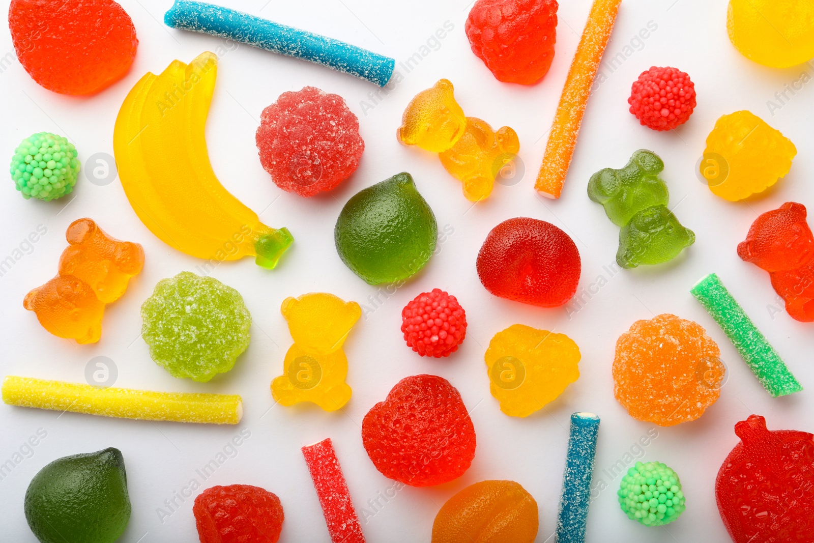 Photo of Mix of different delicious gummy candies on white background, flat lay