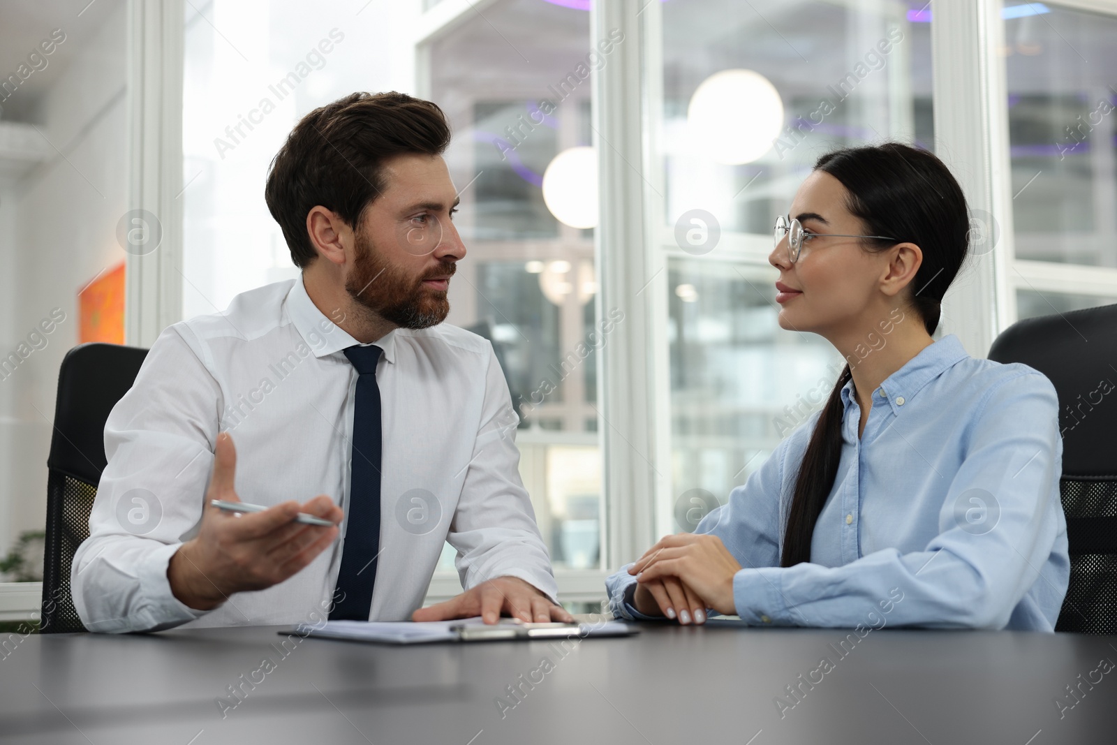 Photo of Lawyers with clipboard working together at table in office