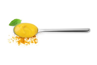 Photo of Spoon with tasty curry sauce, powder and basil leaf isolated on white, top view