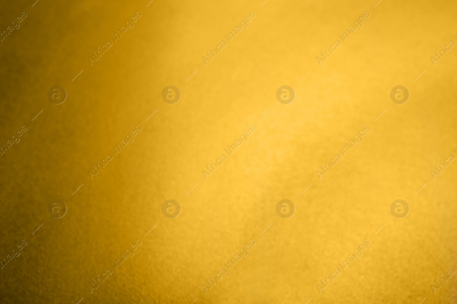 Photo of Blurred view of plain golden surface as background