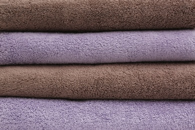 Photo of Stack of folded soft colorful towels as background