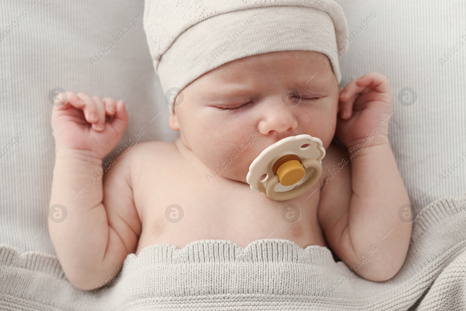 Photo of Adorable little baby with pacifier sleeping in bed, top view