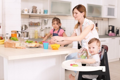 Photo of Housewife preparing dinner with her children on kitchen