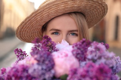 Photo of Woman with bouquet of spring flowers outdoors, closeup