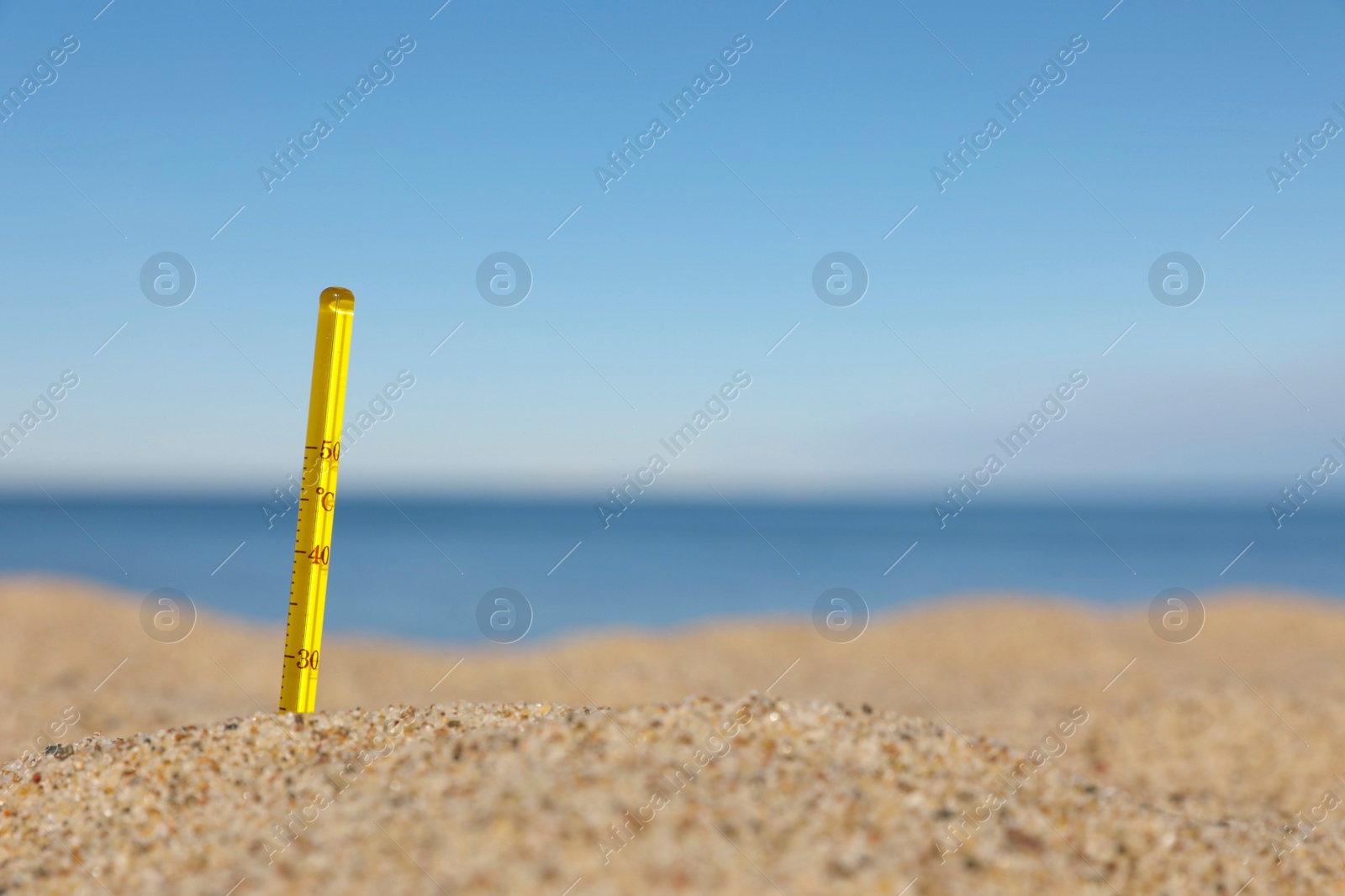 Photo of Weather thermometer in sand near sea, space for text