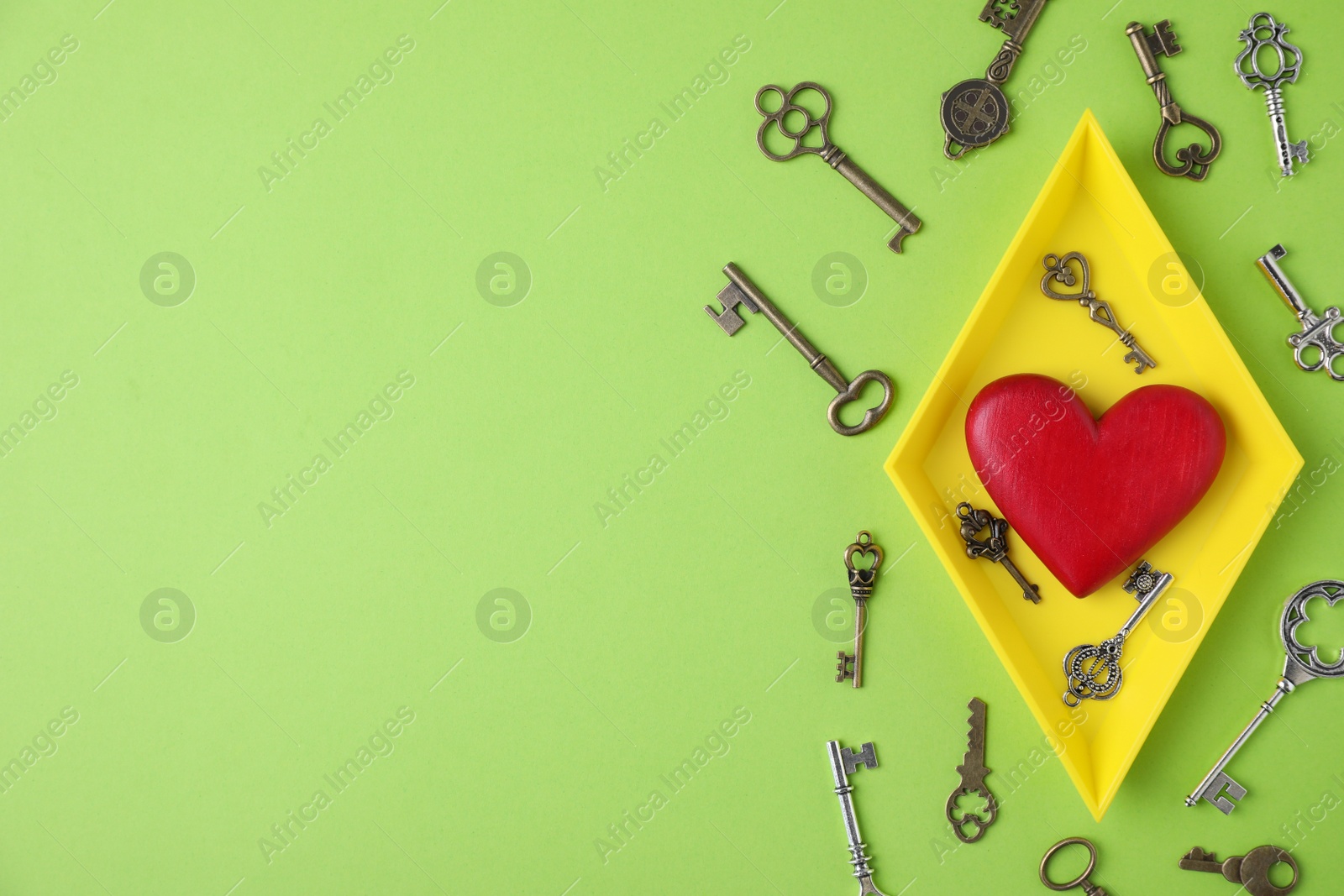 Photo of Flat lay composition with different keys and decorative heart on color background. Space for text