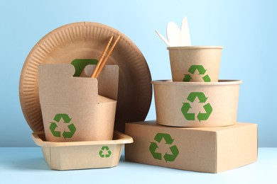 Image of Set of eco friendly food packaging with recycling symbols on light blue background