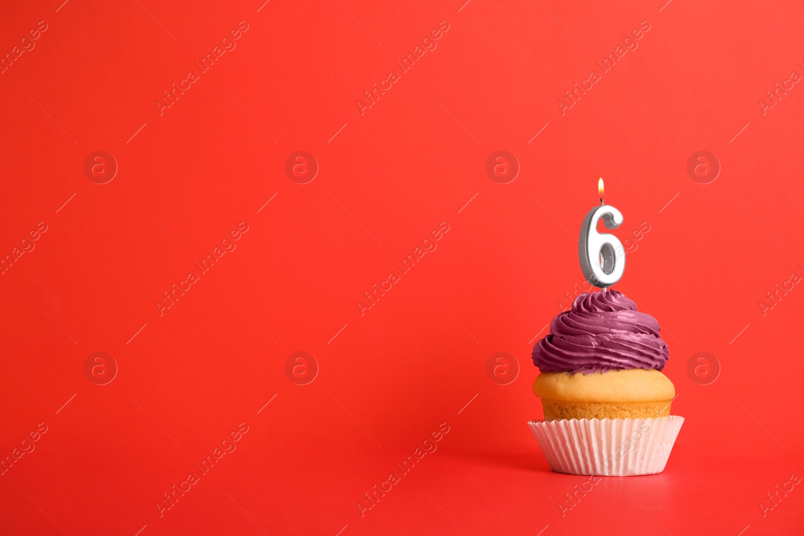 Photo of Birthday cupcake with number six candle on red background, space for text