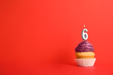 Birthday cupcake with number six candle on red background, space for text