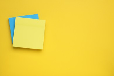 Photo of Paper notes on yellow background, top view. Space for text